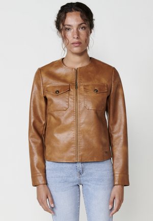 Brown leather jacket with a round neck, front zip, and two chest pockets. Smooth texture, fitted design, and minimalistic detailing.