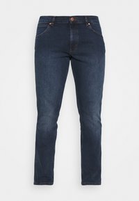 Jeans de mezclilla azul oscuro con un corte slim, cierre de botón, diseño de cinco bolsillos y sutiles acentos de costura en la parte delantera y trasera.
