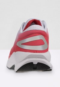 Roter und weißer Sportschuh mit gepolstertem Fersenbereich, reflektierenden silbernen Akzenten und einer strukturierten schwarzen Laufsohle mit Belüftungsöffnungen.