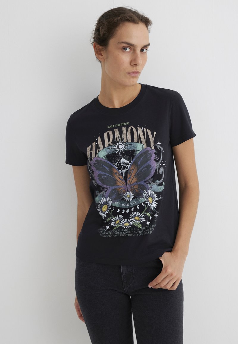 Black cotton t-shirt featuring a large butterfly graphic in purple and orange, surrounded by daisies and text. Short sleeves and a crew neck.