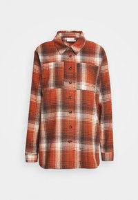 Geruit flanellen overhemd in tinten oranje, bruin en wit. Voorzien van een kraag, lange mouwen en een sluiting met bruine knopen aan de voorkant.
