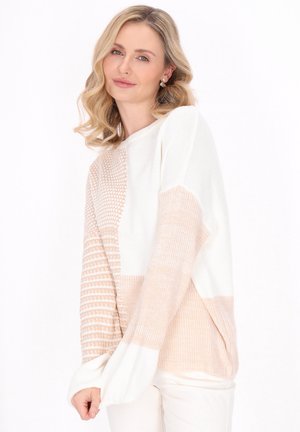 Dikke gebreide trui in wit en lichtbeige, met textuurpanelen en een losse pasvorm. Rib gebreide manchetten en een brede ronde hals voor extra comfort.