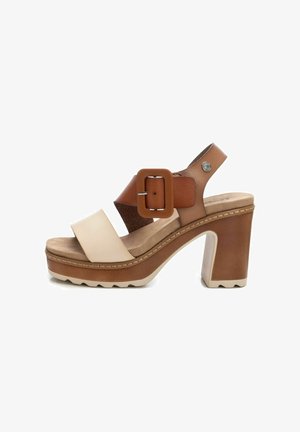 Sandalia de plataforma elevada con una combinación de colores en tonos marrón y beige, que presenta correas anchas, una hebilla cuadrada y un tacón grueso con suela texturizada.