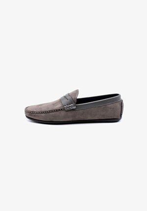 Mocassin en suède gris avec une semelle en caoutchouc plat, une bande en cuir et un détail tissé sur la tige. Design simple et classique avec un embout rond.