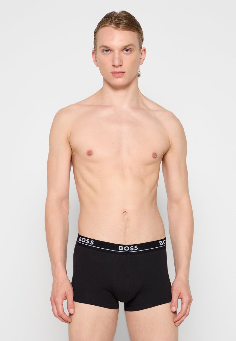 Boxers noirs en coton avec une ceinture de marque portant "BOSS" en lettres blanches. Fabriqués à partir d'un tissu lisse et extensible pour le confort.
