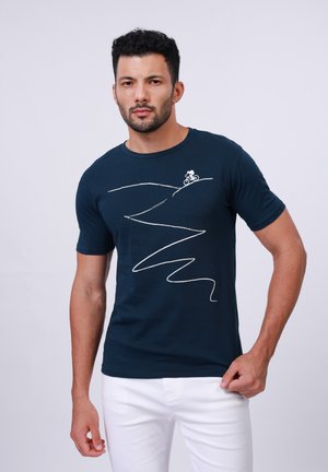 Marineblå bomulds T-shirt med en hvid stregtegning af en cyklist på en bakke, med buede linjer der skildrer en snoet sti. Korte ærmer.