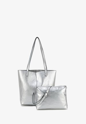 Silberne Tragetasche mit strukturierter Oberfläche und langen Griffen, begleitet von einem kleineren Reißverschlusspouch mit verstellbarem Tragegurt.
