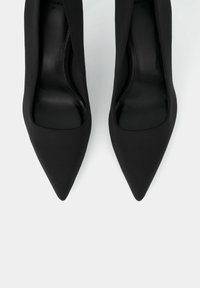 Black high-heeled shoes with a pointed toe and smooth fabric upper. The interior is black leather, featuring a sleek design and minimal detailing.