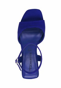 Lila mockasklack sandalett med öppen tå och ankelrem. Har en slät innersula och en platt klack, logotyp präglad på fotbädden.