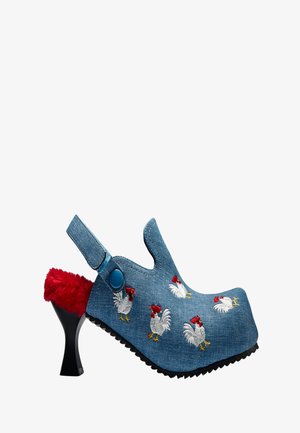 Zueco de mezclilla azul con tacón, interior rojo peludo, bordado de gallo en la parte superior y tacón escultórico negro con correa ajustable.