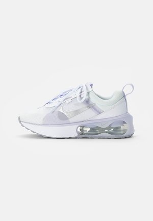 Zapatilla deportiva ligera con parte superior de malla en blanco y púrpura claro, que cuenta con una unidad de amortiguación de aire visible y suela texturizada.