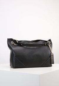 Black leather tote bag with silver chain accents, flat top handles, triangular side details, and a rectangular body. Tag attached.