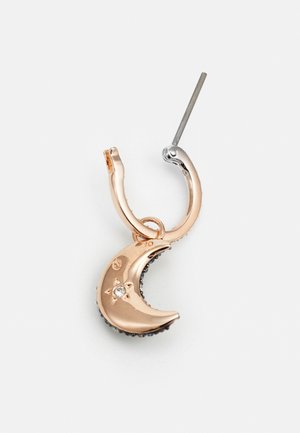 Boucles d'oreilles en or rose en forme de créoles présentant un charm en forme de croissant de lune avec une surface texturée et de petits accents en pierres claires, suspendues à un support en argent.