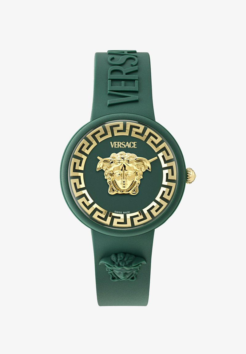 Zelené silikonové hodinky se zlatým emblémem Medusy, zlatým vzorem řeckého klíče a velkým kulatým ciferníkem. Má vyražené logo na pásku.