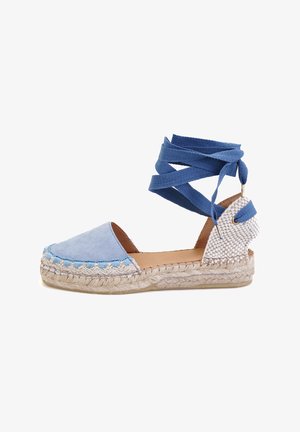 Lichtblauwe espadrille met stoffen bovenkant, jute-wrapped zool en blauwe linten rond de enkel. Heeft een geweven textuur bij de hiel.
