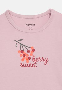 Ροζ παιδικό μπλουζάκι με στρογγυλή λαιμόκοψη, δια κοσμημένο με κλαδί κόκκινων και πορτοκαλί μούρων και λαμπερό κείμενο "μια γλύκα από μούρα".