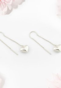 Silberne herzförmige Ohrringe mit Ketten- und geradem Stift-Detail, die ein glänzendes Finish und ein schlichtes, elegantes Design aufweisen.