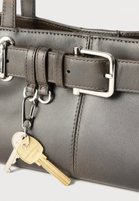 Σκούρα δερμάτινη τσάντα χειρός με ασημένια αγκράφα και δύο κλειδιά προσαρτημένα σε μεταλλικό κρίκο, ένα σε χρώμα ορειχάλκινου και ένα σε ασημί.