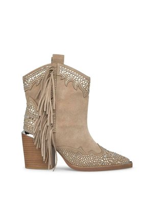 Bottine en suède beige avec un design de lacets découpé, accent frangé, bout pointu et un talon en bois empilé. Détails en clous métalliques.