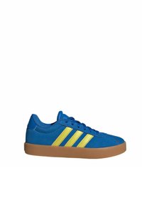 Sneakers en suède bleu avec trois rayures jaunes, semelle plate en caoutchouc, et lacets bleus assortis ; bout rond et dessus en textile.