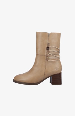 Beige leren enkelboot met een ronde neus, een zijrits en decoratieve veters aan de achterkant. Kenmerken zijn een gestructureerde bruine hak en een logo-accent.