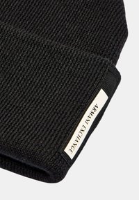 Berretto lavorato a maglia nero con un design testurizzato e risvolto che presenta un'etichetta bianca con la scritta "ARMANI EXCHANGE".