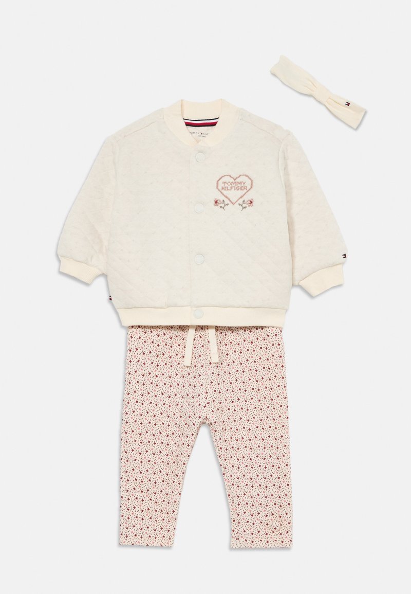 Gepatchte cremefarbene Jacke mit gesticktem Herzdetail, kombiniert mit floral gemusterten Hosen und passendem Haarband. Baumwollmischung, lässiges Design.
