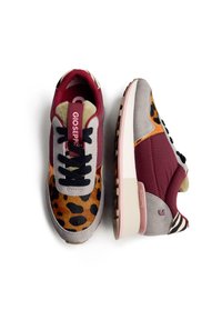 Baskets multicolores présentant un mélange de matériaux bordeaux, gris et imprimé animal, avec un design à lacets et des semelles rembourrées.