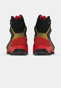 Wysokie trampki z czarną siatkową cholewką, z czerwonymi, żółtymi i pomarańczowymi akcentami, teksturowanymi wzorami oraz gumowymi podeszwami zapewniającymi przyczepność.