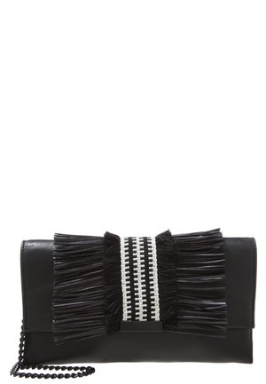 Schwarze Clutch mit einem schwarz-weißen gewebten Band und langen schwarzen Fransen auf der Vorderklappe, mit schwarzem Kettenriemen.