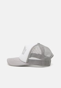 Hvit trucker cap med grå mesh bak og grå skjerm. Har et sydd design på frontpanelet. Standard cap-form.