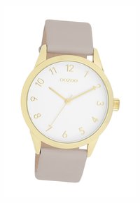 Gold-tone watch with a white dial, minimalist hour markers, and beige silicone strap. Features a round case and simple hands for easy readability.