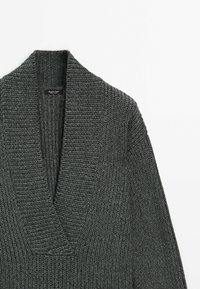 Cardigan en maille gris foncé avec un col en V profond et une texture côtelée. Présente un large col et un tissu doux, mettant l'accent sur le confort et la chaleur.