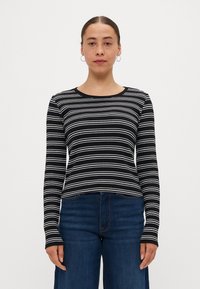 Black and white striped long-sleeve top with a round neckline, made of ribbed fabric, featuring fitted sleeves and a cropped hemline.