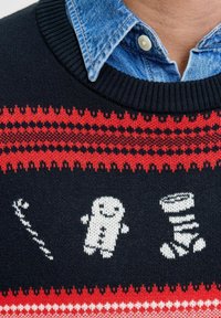 Suéter azul marino con patrones en rojo y blanco. El diseño incluye un palo, un muñeco de nieve y un tornillo, con cuello y puños acanalados.