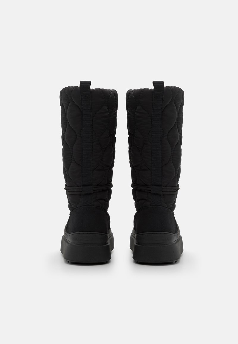 Schwarze, gesteppte, wasserdichte Stiefel mit hohem Schaft, die elastische Akzente und eine strukturierte Sohle aufweisen. Die Rückansicht zeigt einen verstärkten Absatz und Zuglaschen.