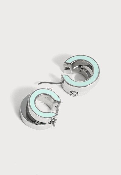 Paire de boucles d’oreilles créoles en argent avec incrustation d’émail bleu clair et fermoirs à charnières sur fond blanc.