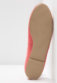 Korallmocka baletttofflor med rund tå, platt tanfärgad gummisula och präglad logotyp på sulan samt mönster som liknar balettskor.