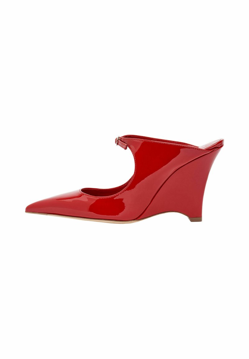 Scarpa a zeppa in vernice rossa con punta affusolata, lati con intagli e tacco sagomato. Finitura lucida con minime decorazioni in metallo.