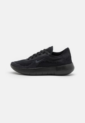 Zapato deportivo negro con una parte superior de malla texturizada, puntera redondeada, cierre con cordones y una suela acolchada que presenta pequeñas protuberancias de goma.