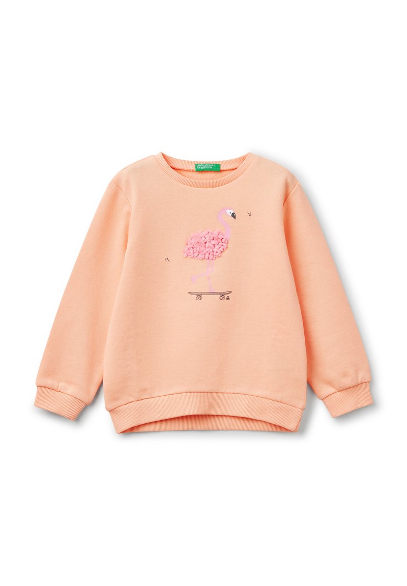 Sweatshirt pêche avec col rond et poignets côtelés. Présente un graphique de flamant rose en peluche sur un skateboard. Tissu doux et texturé.