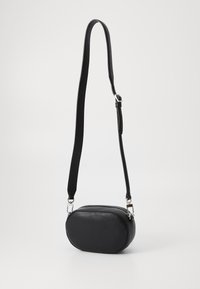 Borsa a tracolla ovale nera realizzata in pelle strutturata, con chiusura a zip e tracolla regolabile con dettagli in metallo argentato.