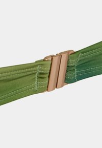 Cintura in tessuto verde con sfumature gradienti, caratterizzata da una superficie liscia e una fibbia in metallo rosa oro. Sono visibili dettagli di cucitura sottili.