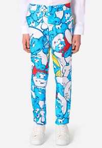 Katoenen broek in een mix met blauwe Smurf-tekeningen op een witte achtergrond, met een slim fit en een standaard tailleband, gecombineerd met witte sneakers.