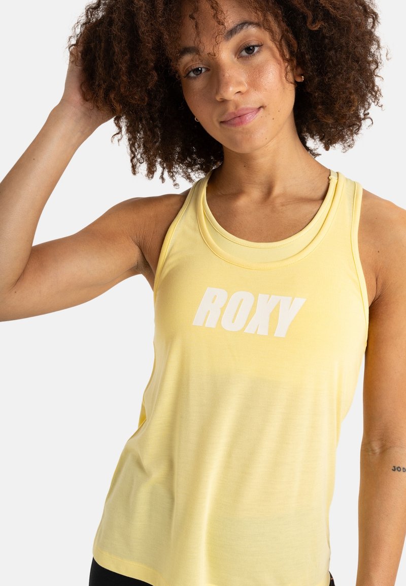 Gelbes sportliches Tanktop mit rundem Ausschnitt, das auf der Vorderseite einen weißen "ROXY"-Aufdruck zeigt. Der Stoff wirkt leicht und glatt.
