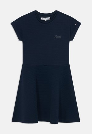 Robe bleu marine à manches courtes avec une jupe évasée, dotée d'un tissu texturé et d'un petit logo imprimé sur le haut de la poitrine.