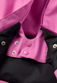 Vaaleanpunainen vedenpitävä takki, jonka sisäosa on musta vuorilla, nepparikiinnityksellä ja kontrastivärisillä ompeleilla. Sileä pinta ja joustava kangas.