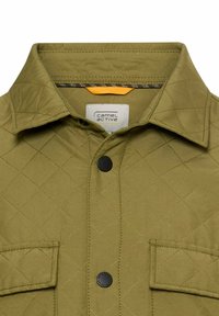 Quilted olive green jacket with a pointed collar, black snap buttons, and chest pockets. Interior features contrast stitching and branding.