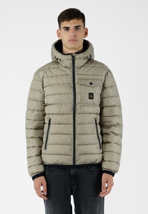 Giubbotto imbottito di un beige chiaro con trapuntatura orizzontale, zip frontale, cappuccio e due tasche laterali. Presenta una tasca sul petto con un logo.
