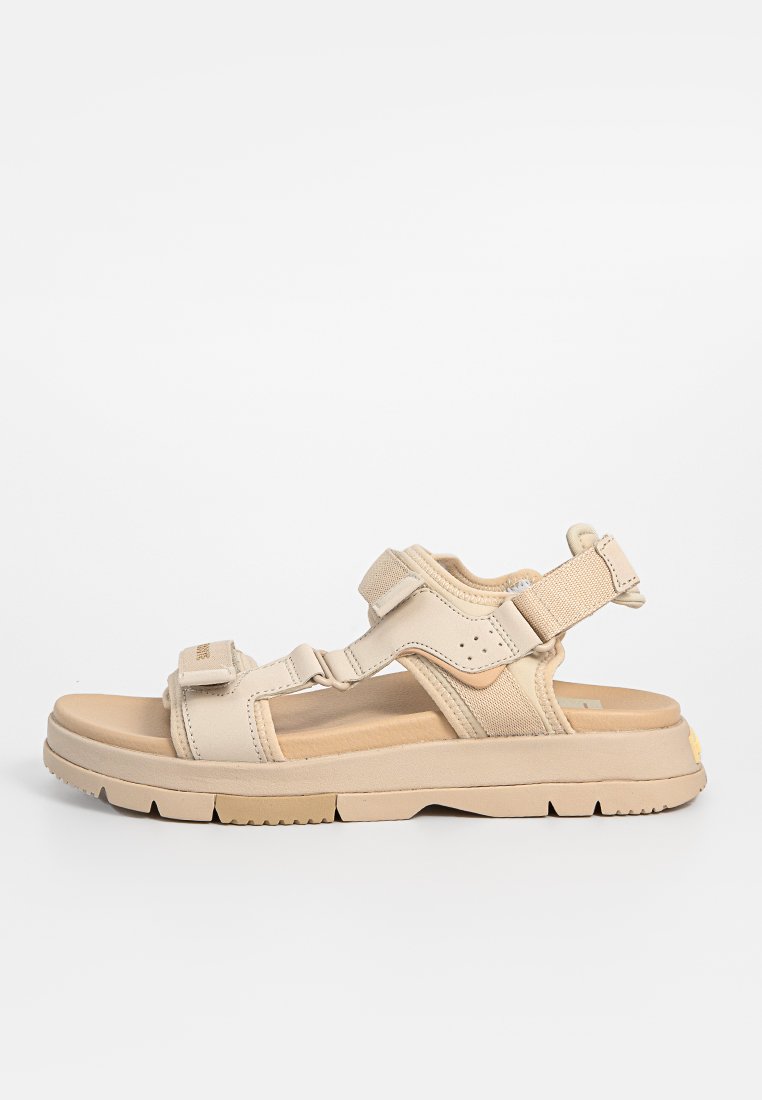 Sandales à plateformes beiges avec des lanières réglables, semelle rembourrée et semelle extérieure texturée pour une meilleure adhérence. Design minimaliste avec une quincaillerie robuste.